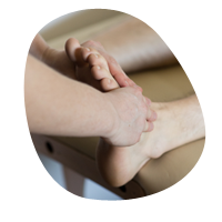 Humanphysiotherapie - Hände, die einen Fuß abtasten